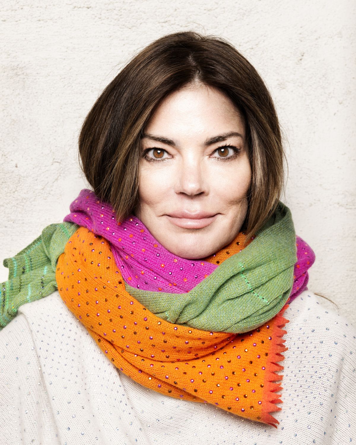 Woman wearing colorful cashmere scarves with embellished with fine Austrian crystals and metal rhinestones. 