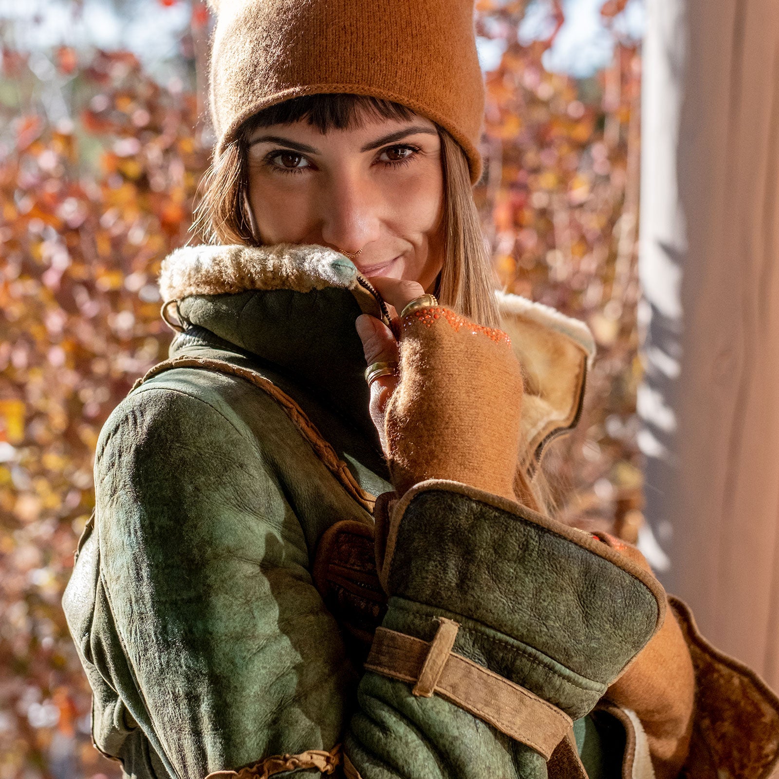 Model wearing Elyse Allen Textiles showing chestnut colored cashmere Triangle Gloves. editorial-image