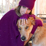 Woman wearing luxury cashmere fingerless gloves hugging a dog. editorial-image
