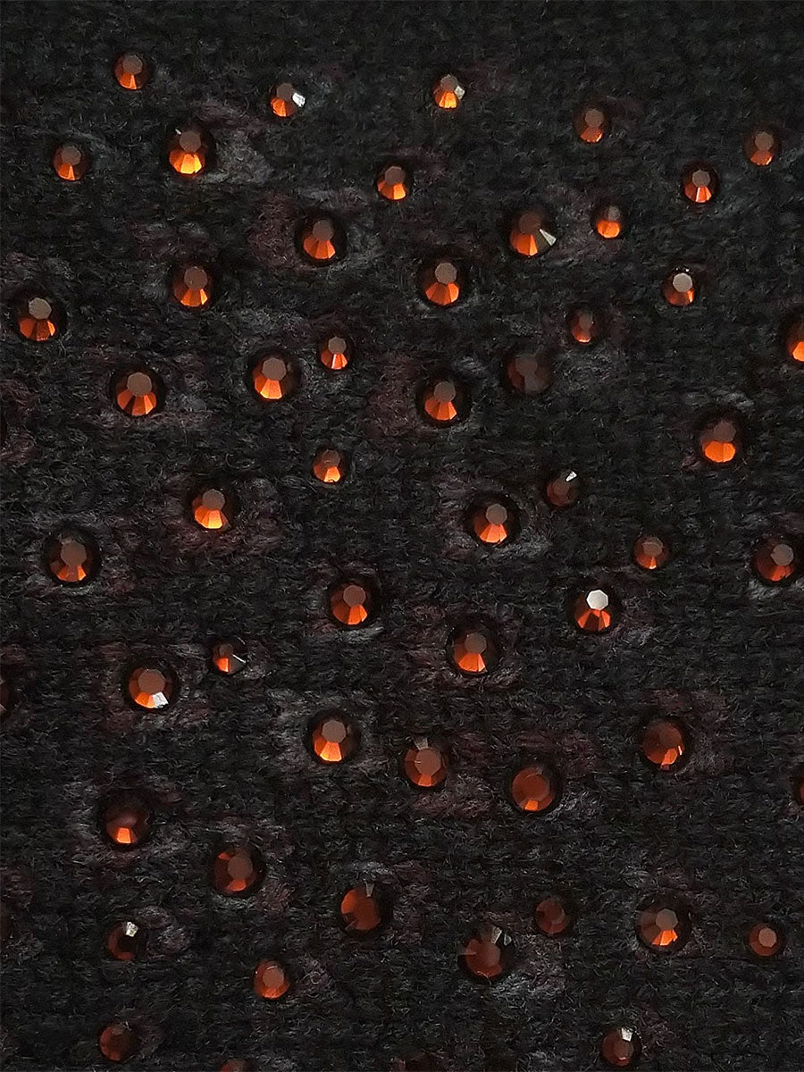 Black cashmere fabric swatch embellished with red crystals.