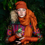 Estrella Cloche editorial-image of model wearing saffron colored cashmere textiles in a forest setting. editorial-image