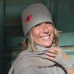editorial-image of a smiling woman wearing a "Heart Cloche" in Chanterelle by Elyse Allen Textiles. 