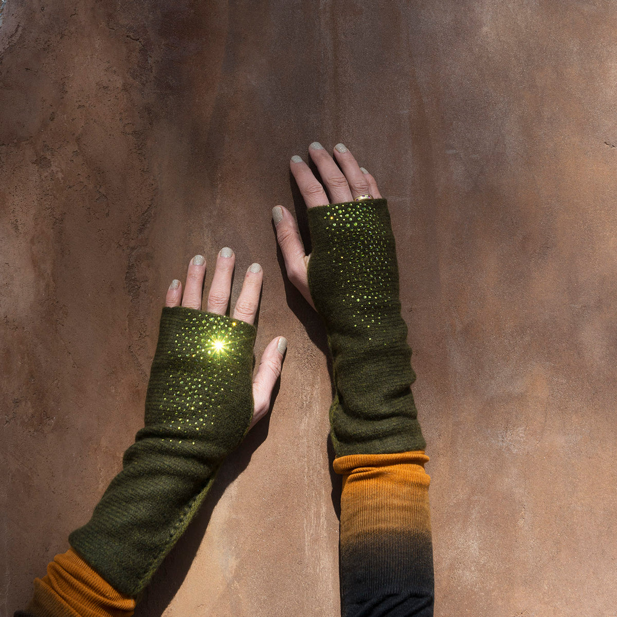 Hands modeling Olive colored Mid Length Hydra Fingerless Gloves. editorial-image