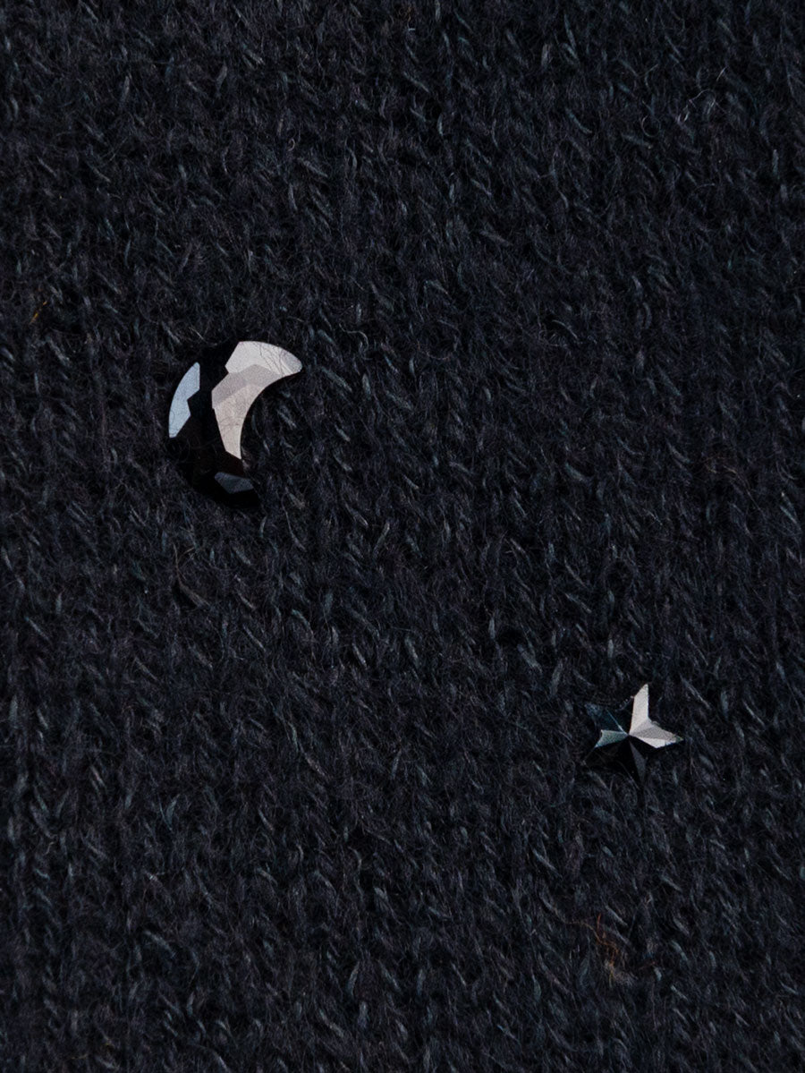 Close-up of jet colored moon and star crystals on black cashmere.