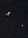 Close-up of jet colored moon and star crystals on black cashmere.