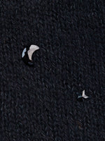Close-up of jet colored moon and star crystals on black cashmere.