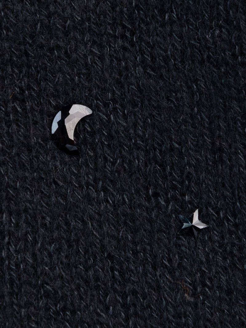 Close-up of jet colored moon and star crystals on black cashmere.